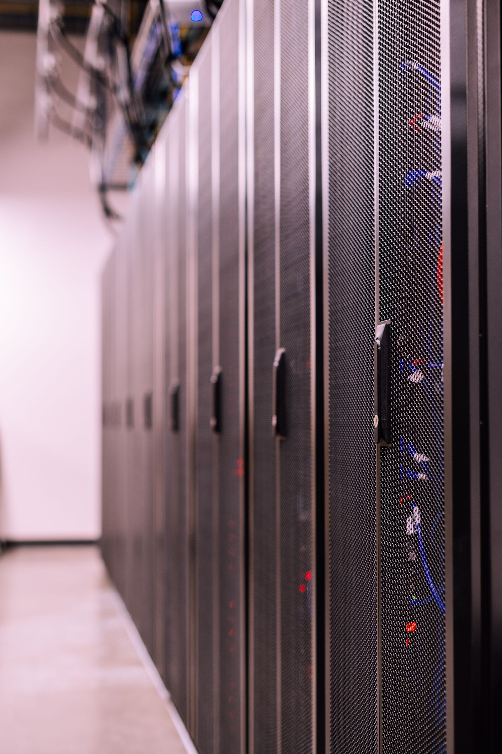 A close view along a row of server cabinets in a data centre